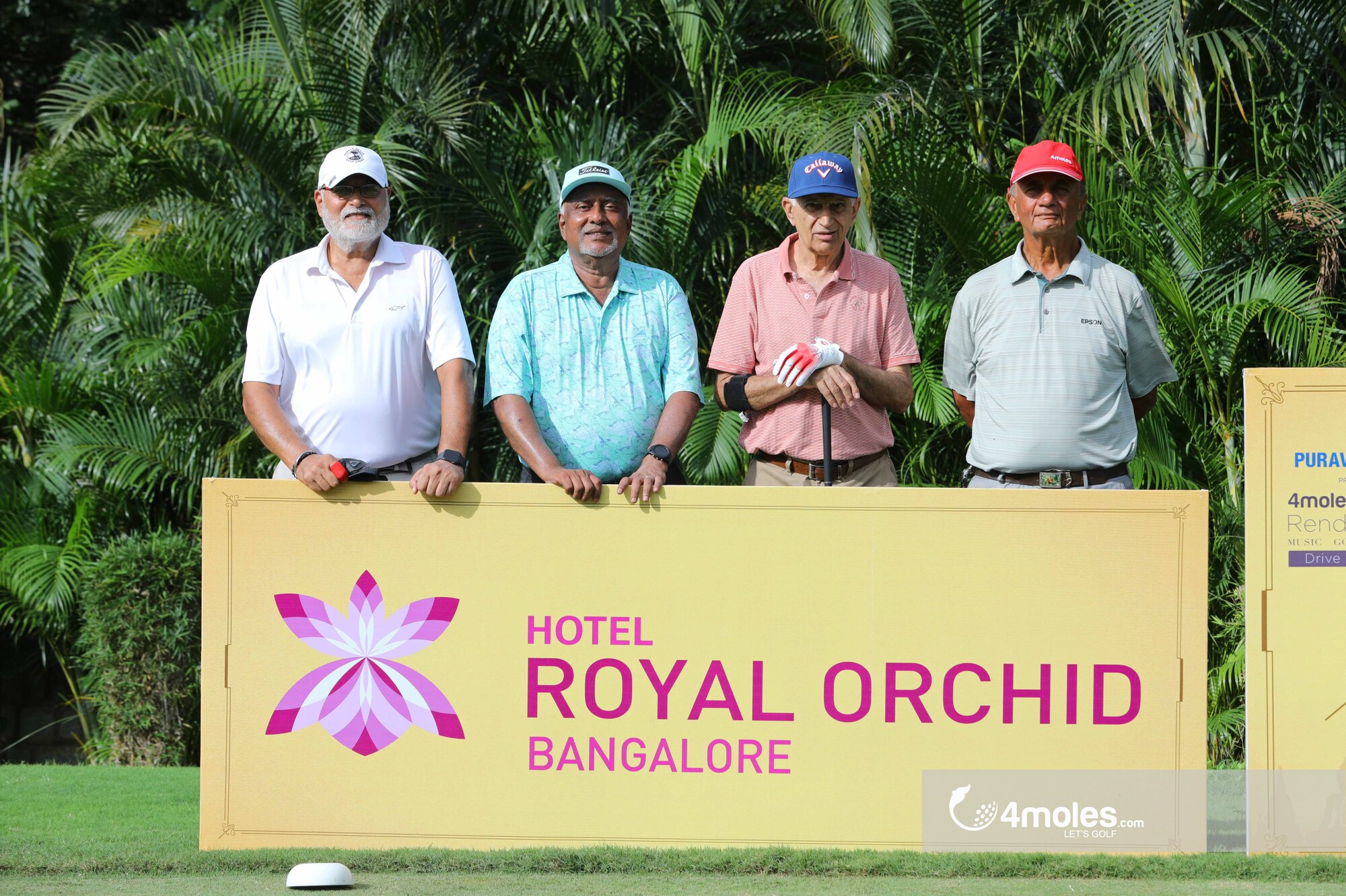 Golfers posing with Royal Orchid sign.