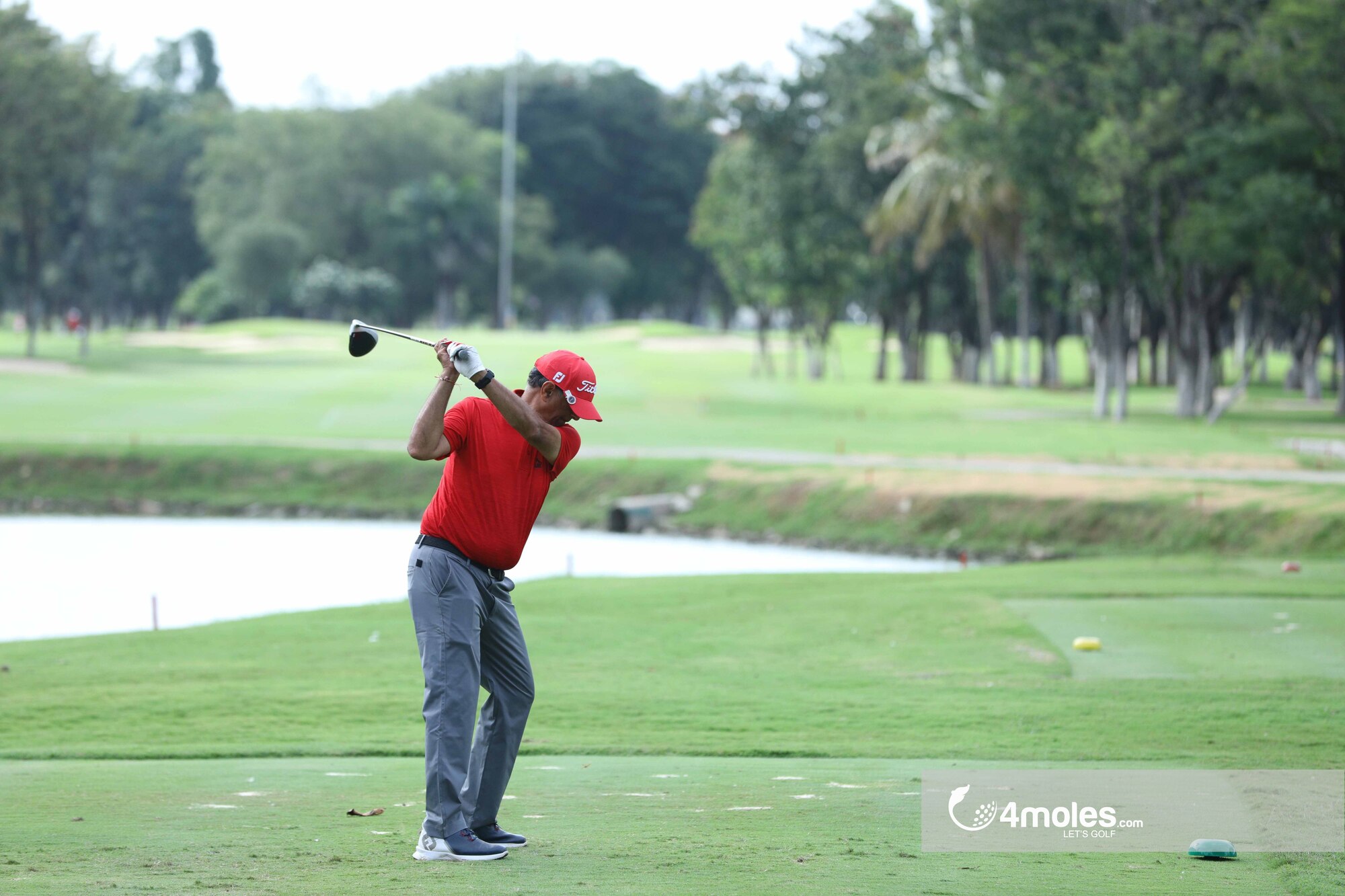 Precision shot by a red-clad golfer.